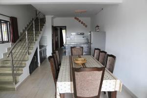 une salle à manger avec une table, des chaises et un escalier dans l'établissement 3 Bedroom Family Pool Villa Flic-en-Flac Beach, à Flic-en-Flac