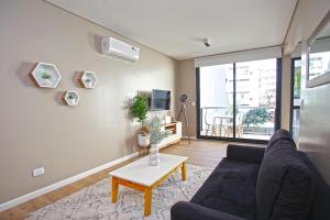 a living room with a couch and a table at Fancy 1BR Apartment in Nuñez in Buenos Aires