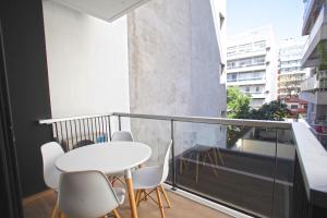 a balcony with a white table and chairs at Fancy 1BR Apartment in Nuñez in Buenos Aires