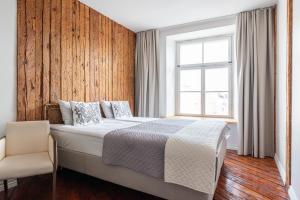 a bedroom with a bed and a window and a chair at Old Town - Boutique Hall Square Apartment in Tallinn