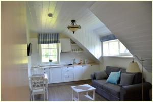 a living room with a couch and a kitchen at Vila Preila in Neringa
