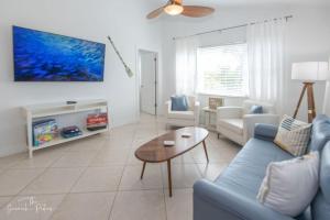 uma sala de estar com um sofá azul e uma mesa em Hutchinson Island Beach House - Sleeps 32 - 8 BD em Fort Pierce