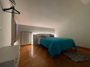 - une chambre avec un lit et une couverture bleue dans l'établissement LHE Maison Almerici, à Cesena