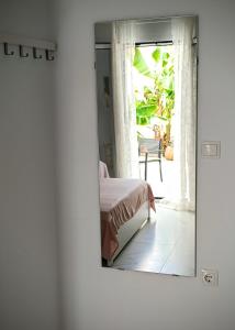a mirror reflecting a bedroom with a bed and a window at FlatFifty in Ierápetra +37 photos