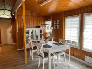 une salle à manger avec une table et des chaises blanches dans l'établissement Haus Haddorfer See "Hus vi d Sjön", à Wettringen
