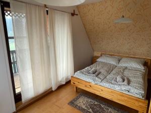 a small bedroom with a bed and a window at Dom Znajomych - cały dla Ciebie, ogrodzony, wygodny in Złatna