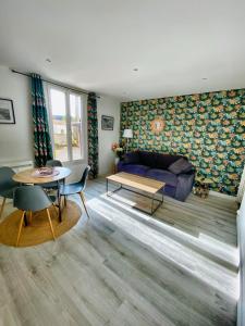 una sala de estar con un sofá y una mesa en Maison ville T2 quartier calme Parking Gratuit, en Saint-Julien-les-Villas