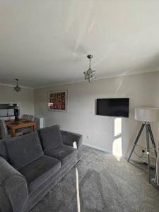 a living room with a couch and a flat screen tv at The Castle in Killingworth