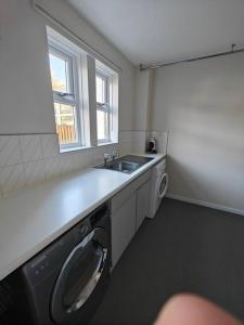 a kitchen with a sink and a washing machine at The Castle in Killingworth