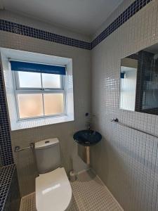 a bathroom with a toilet and a sink and a window at The Castle in Killingworth