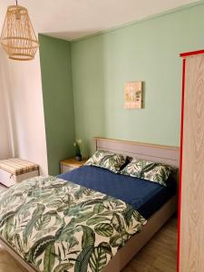 a bedroom with a bed with a blue comforter at Ibiza Apartment - 150m from the beach in Flic-en-Flac