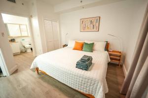 a bedroom with a large white bed with orange and green pillows at Renovated Condo Blue Heron 5 pax in Orlando +23 photos