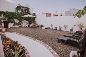 a patio with a bunch of chairs and an umbrella at Casa Marita 11 in Los Llanos de Aridane