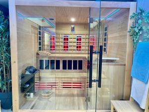 a sauna with a glass door in a room at Ferienhaus Glücklich am Meer 3 mit Wellnesszugang in Egmond aan Zee