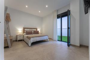 um quarto com uma cama e uma grande janela em CMDreams Platinium- Apartamentos turísticos en el centro de Mérida em Mérida