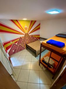 Pokój z 2 łóżkami piętrowymi i kolorową ścianą w obiekcie HOSTEL Divinópolis w mieście Divinópolis