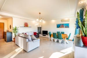 uma sala de estar com um sofá e cadeiras em Relaxing and Central T3 Flat em Portimão