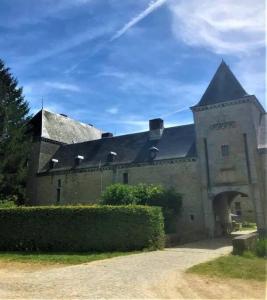 a large stone building with a black roof at Le Papillon in Hotton
