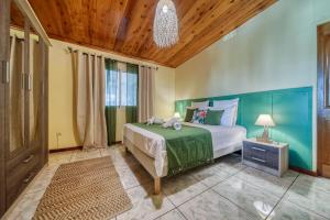 sypialnia z dużym łóżkiem i drewnianym sufitem w obiekcie Kaz Latania w mieście Étang-Salé