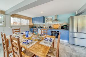 a kitchen with a wooden table and blue cabinets at Kaz d Abord in Saint-Pierre