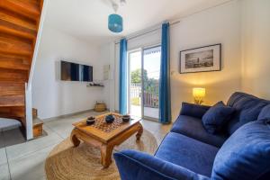 a living room with a blue couch and a table at Kaz d Abord in Saint-Pierre