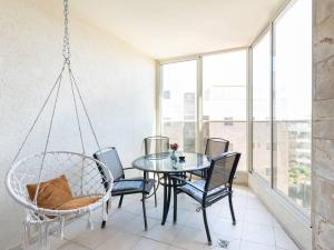 里雄莱锡安Neat 4BR Apt. With Parking/High Floor/Elevator/AC的有桌子和椅子的餐厅