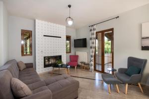 a living room with a couch and chairs and a fireplace at Villa Alex with private pool and jacuzzi in Prinés