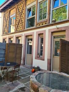 un edificio con un patio con una mesa en Ancien séchoir du 19ème siècle, en Saint-Dié-des-Vosges