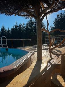 a wooden deck with a swimming pool and a umbrella at Bonaluti in Mirsk