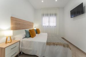 um quarto com uma grande cama branca e uma janela em CMDreams Platinium- Apartamentos turísticos en el centro de Mérida em Mérida