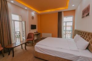Habitación de hotel con cama, escritorio y ventanas en Madinah Hotel en Bakú