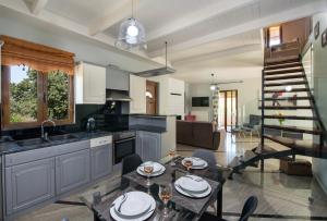 a kitchen and living room with a table and chairs at Villa Alex with private pool and jacuzzi in Prinés