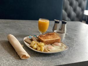 a plate of breakfast food with a glass of orange juice at DoubleTree by Hilton Utica in Utica