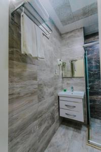 a bathroom with a glass shower and a sink at Madina-ZamZam Halal Hotels Group in Baku