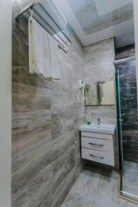 a bathroom with a glass shower and a sink at Madinah Hotel in Baku