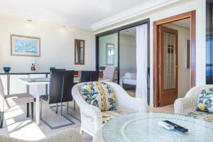 ein Wohnzimmer mit Stühlen und einem Tisch in der Unterkunft Santa Margarita 15-E Apartment Levante Beach in Benidorm