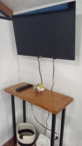 a television on a table with a remote control on it at LA CASITA DE PUEBLO NUEVO in Puerto Limón