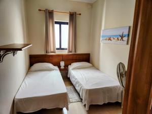 een kamer met 2 bedden en een raam bij Seafront Apartment - Wifi - Sleeps 6 - ChrisCourt in Marsaskala