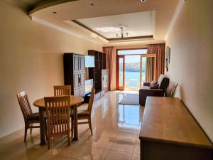 een keuken en een woonkamer met een tafel en stoelen bij Seafront Apartment - Wifi - Sleeps 6 - ChrisCourt in Marsaskala