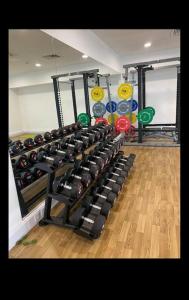 a gym with a rack of dumbbells in a room at Stylish Media city Manchester apartment in Manchester