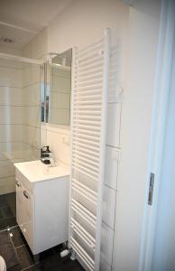a white bathroom with a sink and a mirror at ZENITH STAY - hochwertige Apartments direkt in der Innenstadt in Erkelenz +71 photos