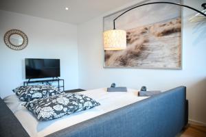 a bedroom with a bed with a lamp and a tv at ZENITH STAY - hochwertige Apartments direkt in der Innenstadt in Erkelenz