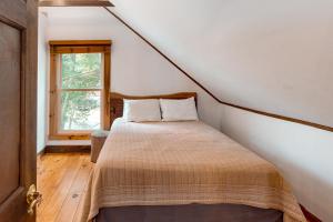 1 dormitorio con cama y ventana en Long Island Road Getaway en Moultonborough