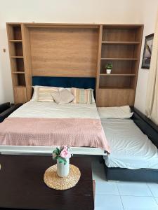 a bedroom with two beds and a table with a pot of flowers at Studio in Al Furjan - Near Metro Dubai & Expo 2020 in Dubai