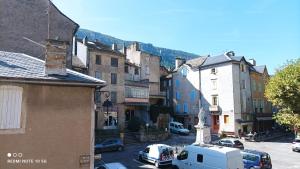 a town with cars parked on a street with buildings at FLORAC AUTHENTIQUE in Florac