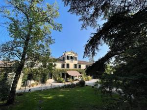 una grande casa bianca con alberi di fronte di B&B Villa Gradenigo a Lancenigo