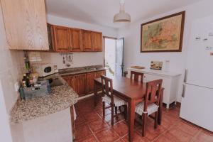 a kitchen with a wooden table and a refrigerator at Casa Marita 11 in Los Llanos de Aridane