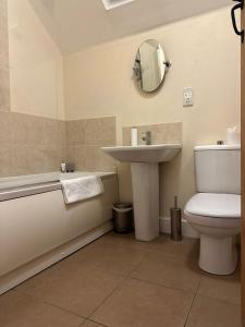 une salle de bain avec un lavabo, des toilettes et un miroir dans l'établissement Cosy & peaceful cottage in rural Northumberland, à Morpeth