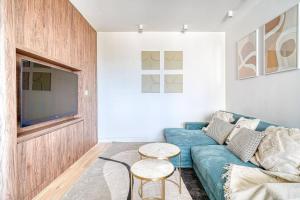 ein Wohnzimmer mit einem blauen Sofa und einem TV in der Unterkunft Appartement de luxe - Aux portes de Paris in Saint-Mandé