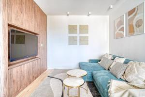 a living room with a blue couch and a tv at Appartement de luxe - Aux portes de Paris in Saint-Mandé
